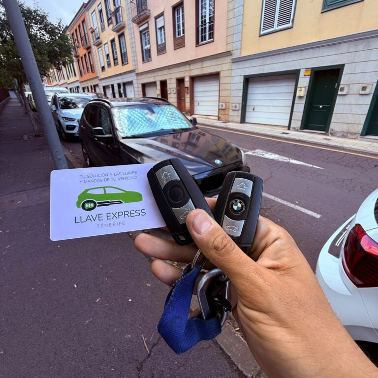 Dos mandos de BMW junto al coche y la tarjeta de Llave Express Tenerife.