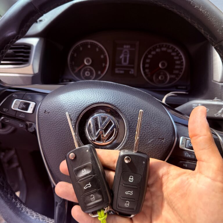 Dos llaves plegables con mando ante el volante de un Volkswagen.