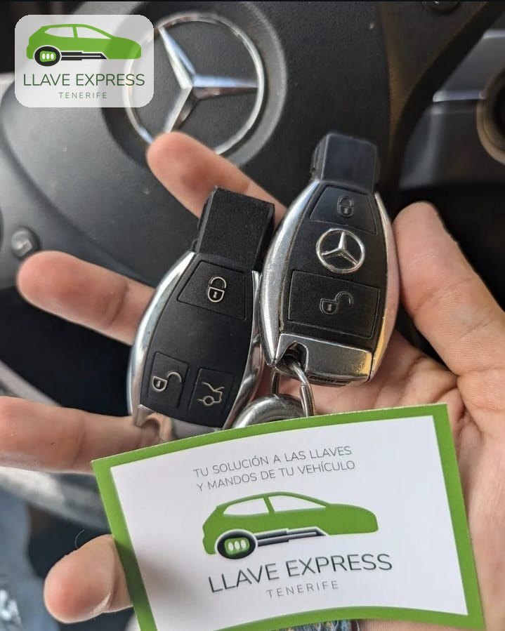 Dos mandos de Mercedes-Benz sobre una mano, frente al volante, junto a una tarjeta de Llave Express Tenerife.